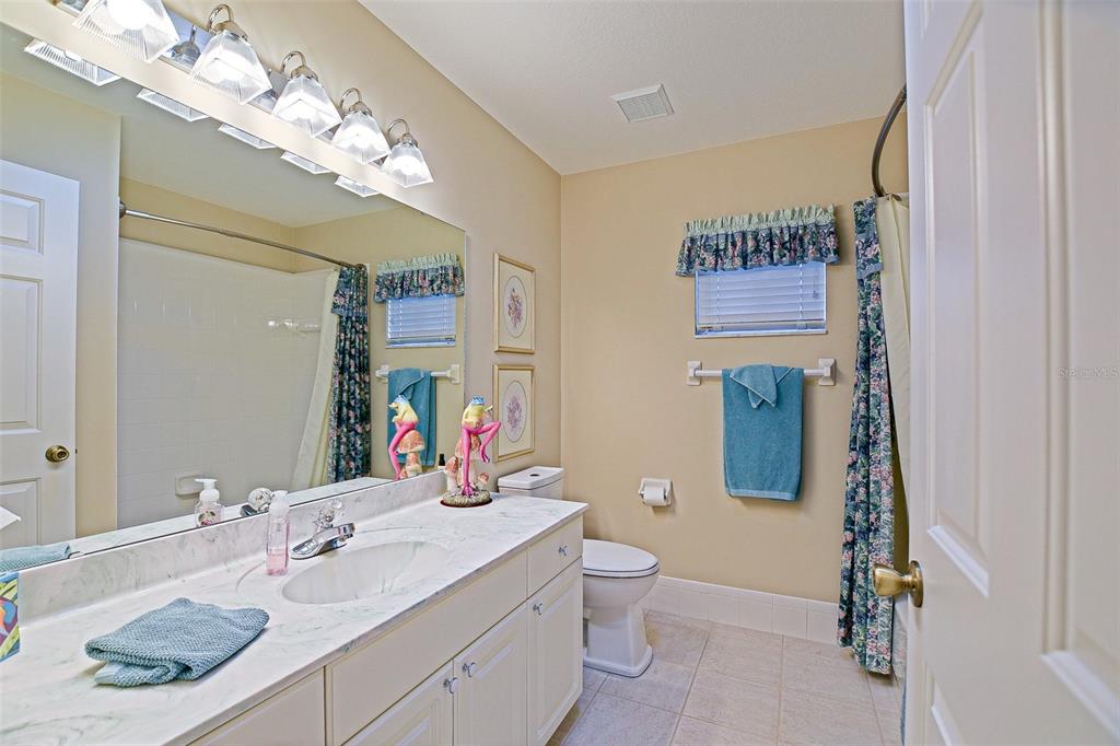 8850 Southeast 140th Place Road Summerfield, FL 34491 - Photo 62 of 98 a bathroom with a granite countertop sink vanity mirror and toilet