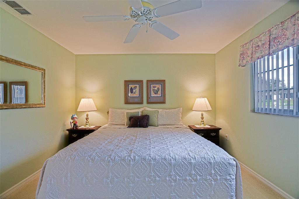 8850 Southeast 140th Place Road Summerfield, FL 34491 - Photo 64 of 98 a bedroom with a bed and a chandelier