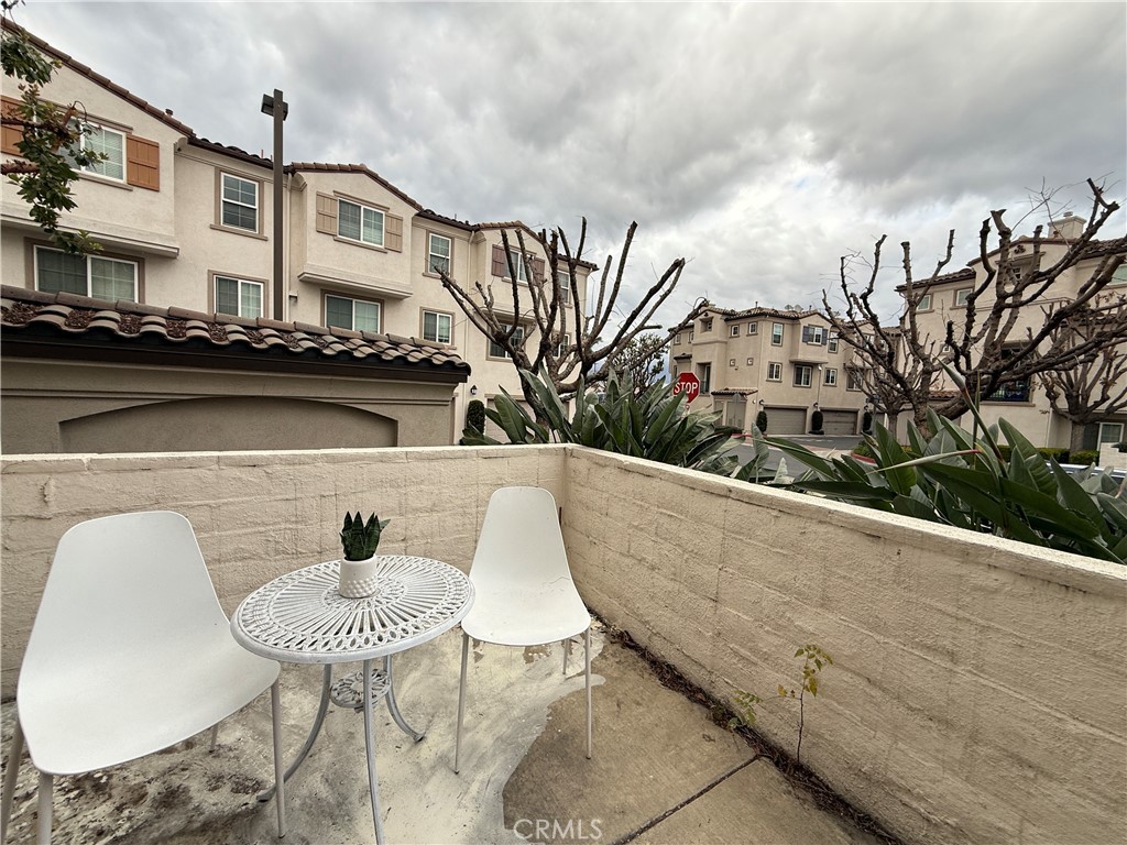 a roof deck with table and chairs and potted plants