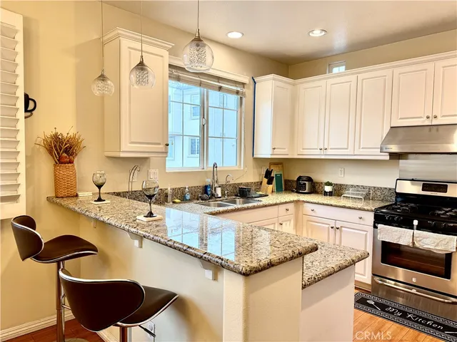 a kitchen with granite countertop a sink a counter top space appliances and cabinets
