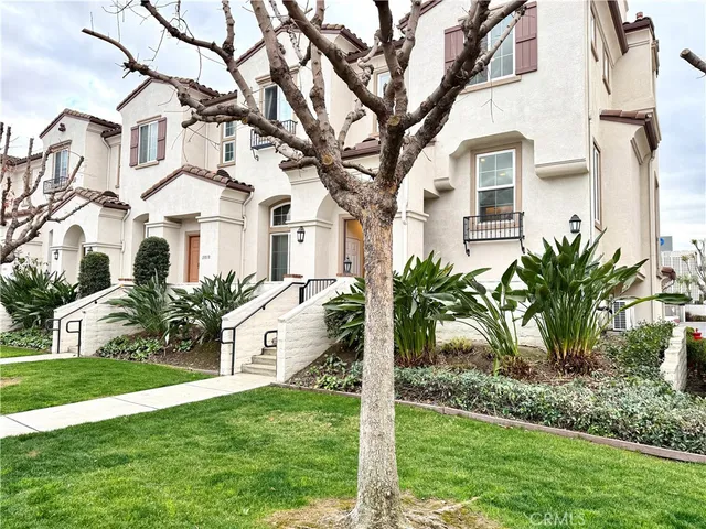 a front view of a house with a yard and palm trees