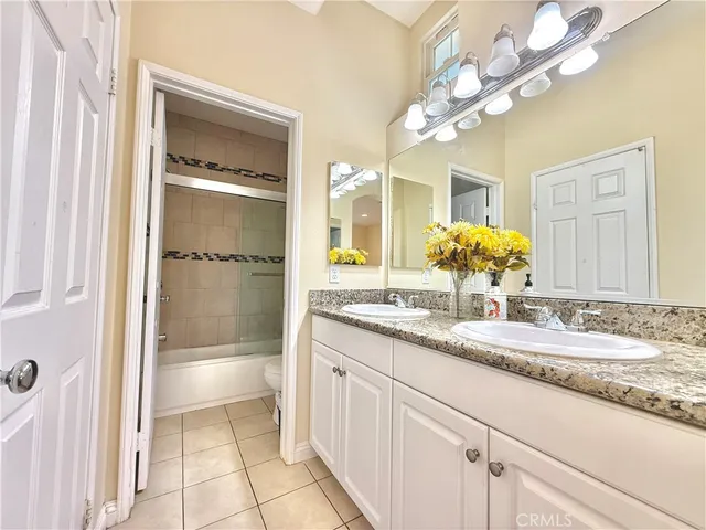 a bathroom with a granite countertop sink a mirror and a shower