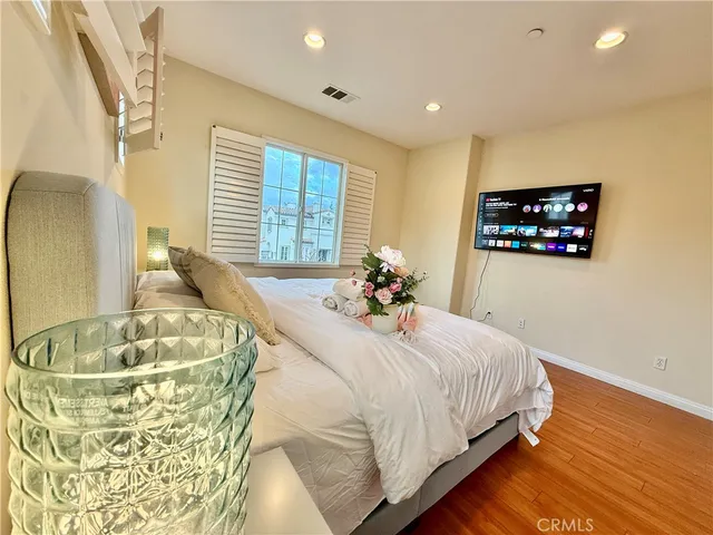 a bed sitting in a spacious bedroom next to a window and a chandelier
