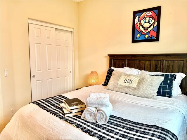 a bedroom with a bed and a painting on the wall