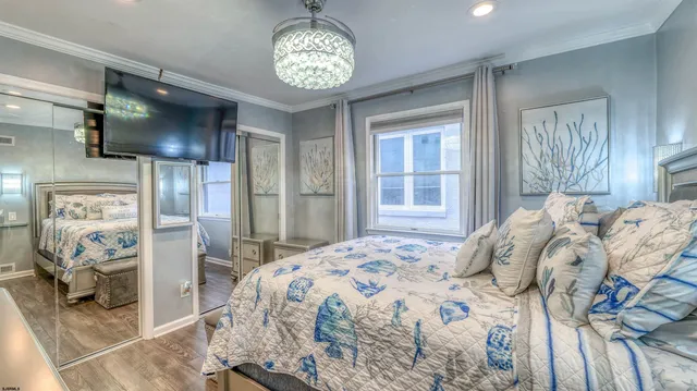 a bedroom with a large bed and a chandelier