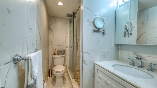 a bathroom with a granite countertop sink toilet and shower