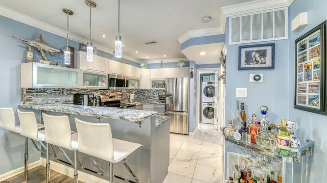 a kitchen with stainless steel appliances granite countertop a sink refrigerator and cabinets
