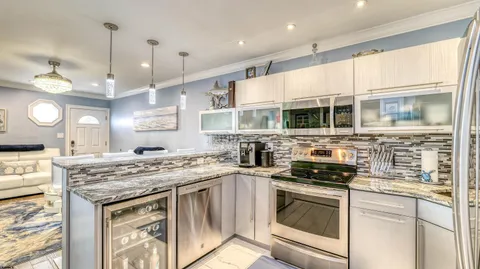 a kitchen with stainless steel appliances granite countertop a stove sink and cabinets