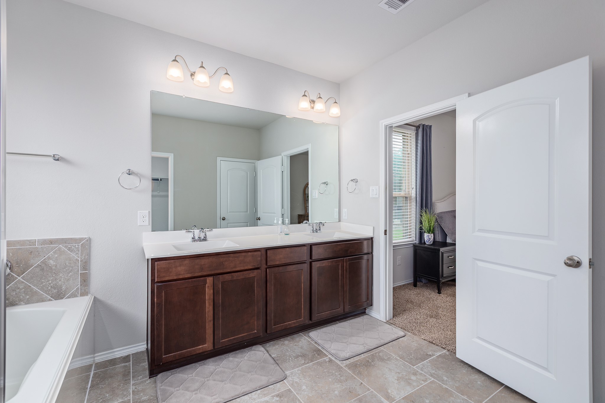5611 Claymore Meadow Lane Spring, TX 77389 - Photo 19 of 32 a spacious bathroom with a double vanity sink a mirror and a bathtub