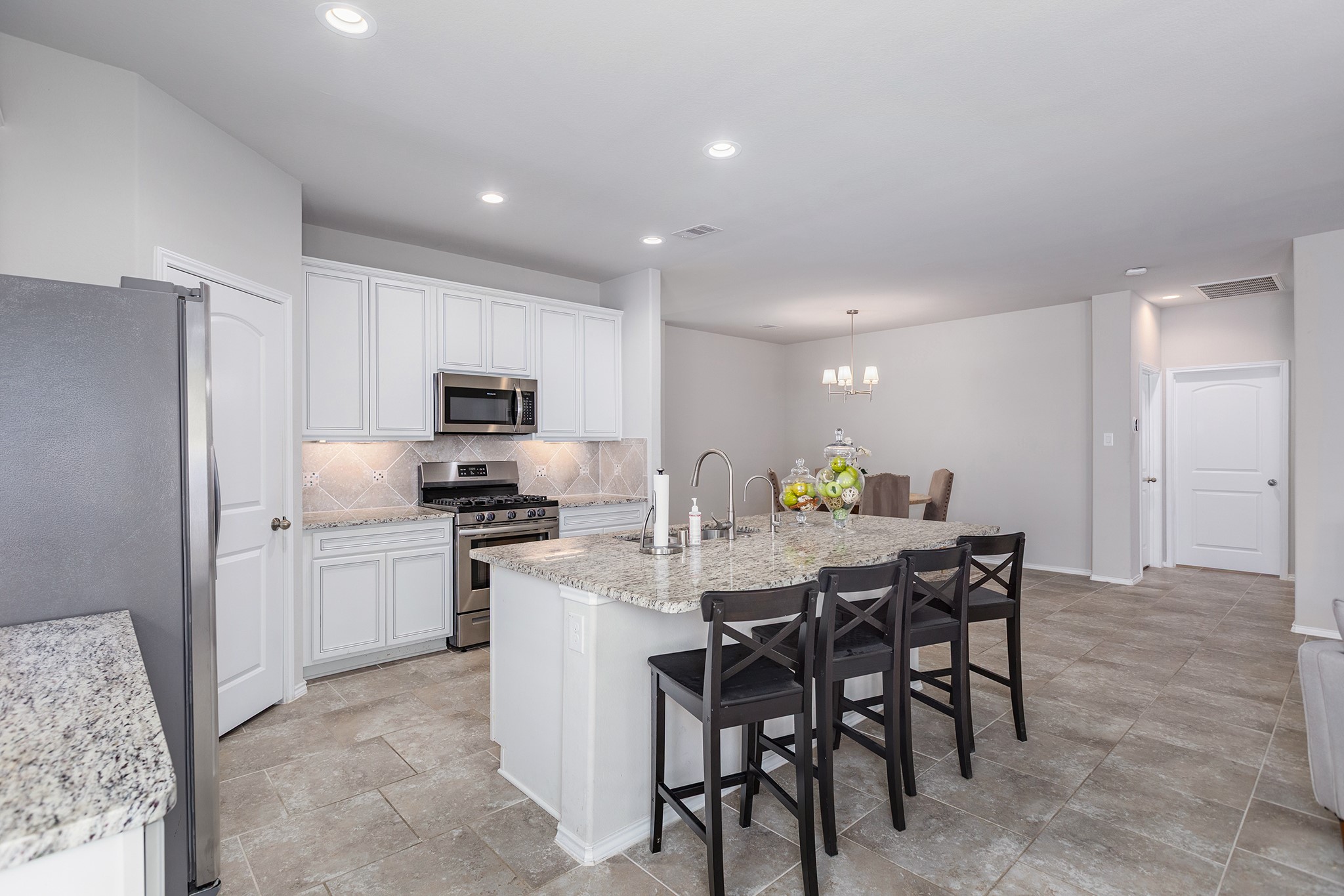 5611 Claymore Meadow Lane Spring, TX 77389 - Photo 6 of 32 a kitchen with a dining table cabinets appliances and a counter space