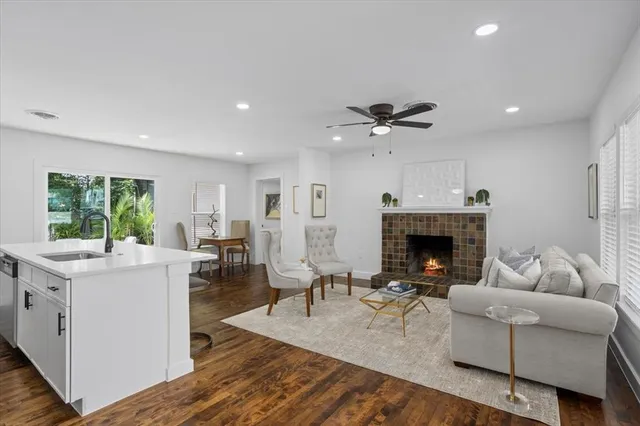 a living room with furniture a fireplace and a ceiling fan