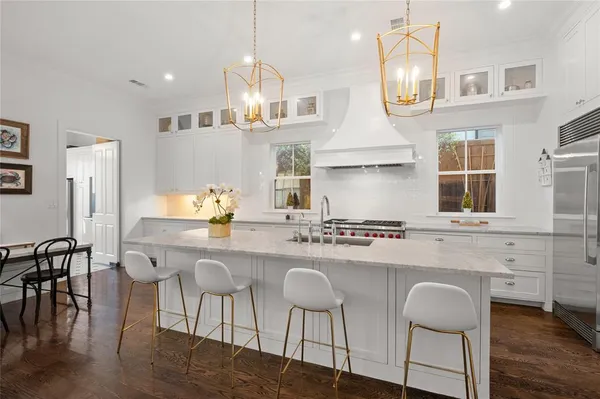 a kitchen with cabinets a sink stainless steel appliances and dining table