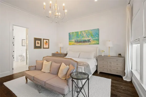 a spacious bedroom with a bed and a chandelier