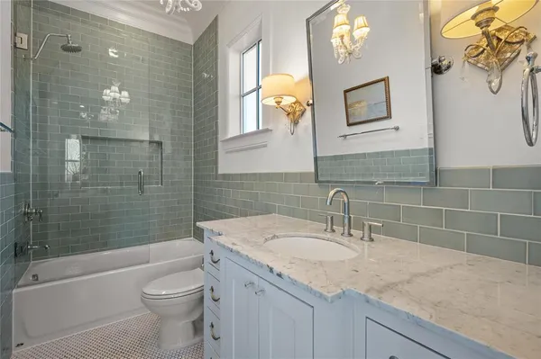 a bathroom with a granite countertop sink a toilet and shower