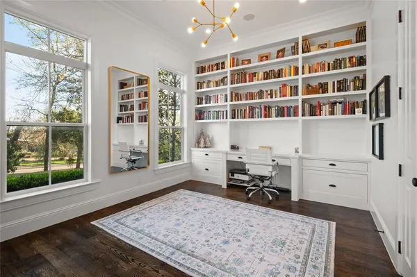 a view of a workspace with furniture and a book shelf