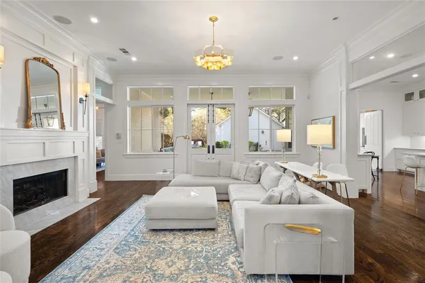a living room with furniture a chandelier and a fireplace