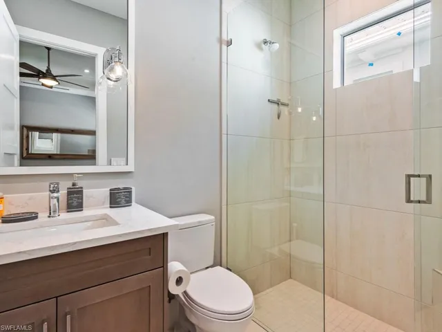 a bathroom with a toilet a sink a shower and mirror