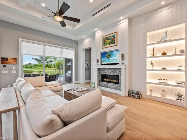 a living room with furniture fireplace and a large window