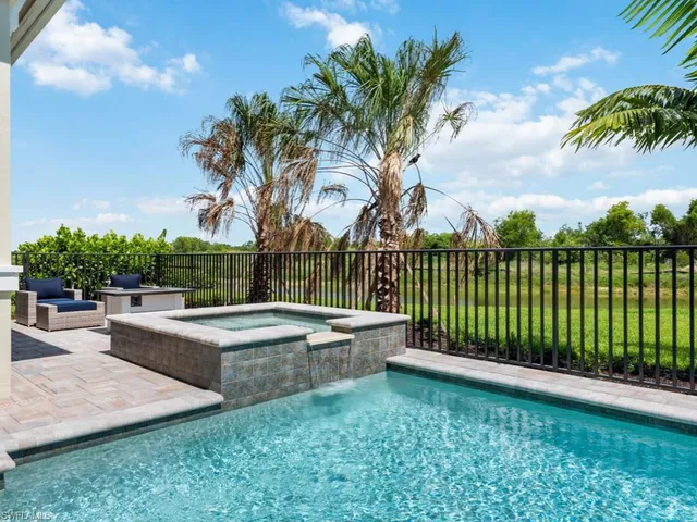 a view of a backyard with swimming pool and sitting area