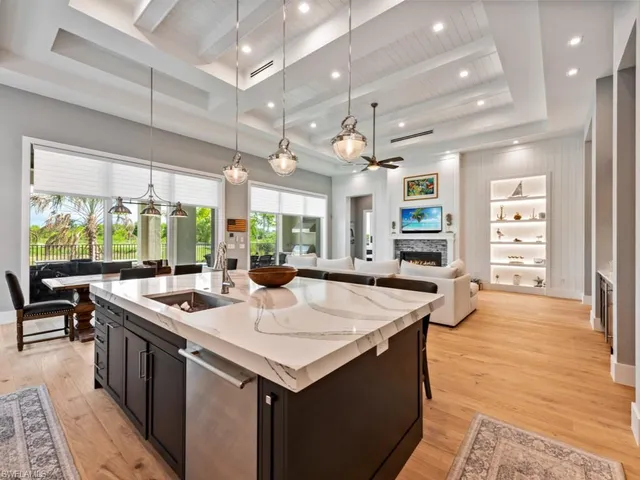 an open kitchen with kitchen island a sink stove and a large window