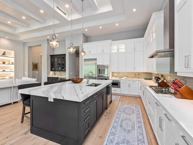 a large kitchen with stainless steel appliances lots of counter space and window in it