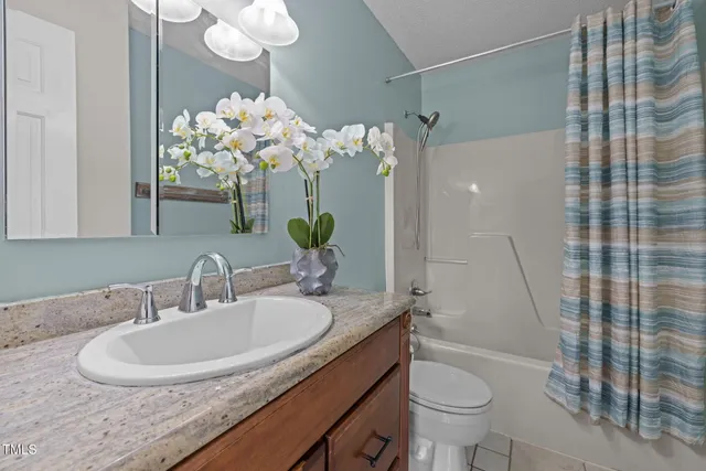 a bathroom with a granite countertop sink a toilet and a mirror