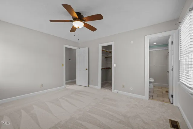 an empty room with closet and windows