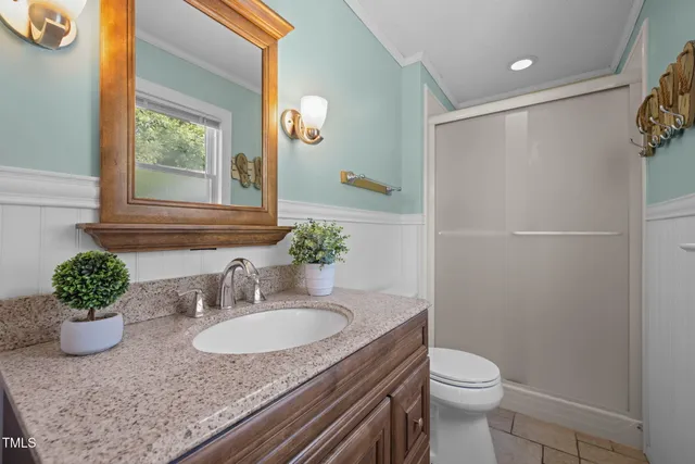 a bathroom with a granite countertop sink a toilet and a mirror