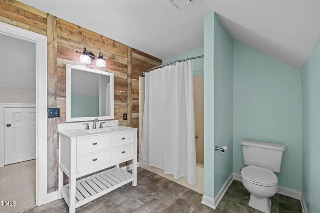 a bathroom with a sink toilet vanity and shower
