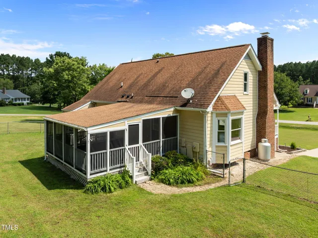 a view of house with backyard and sitting area
