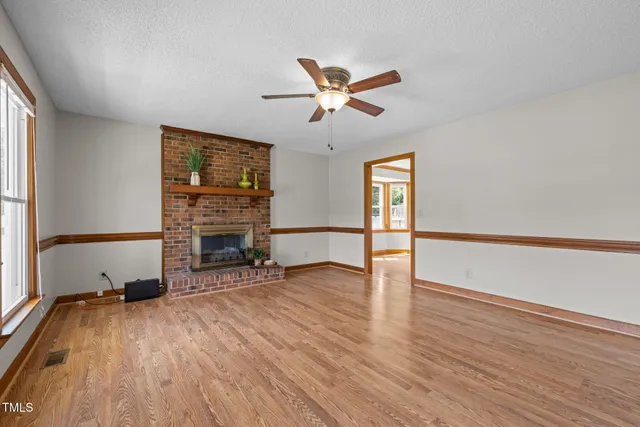 a view of a livingroom with wooden floor and a ceiling fan