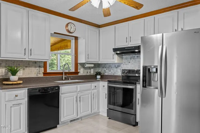 a kitchen with stainless steel appliances granite countertop a refrigerator sink and cabinets