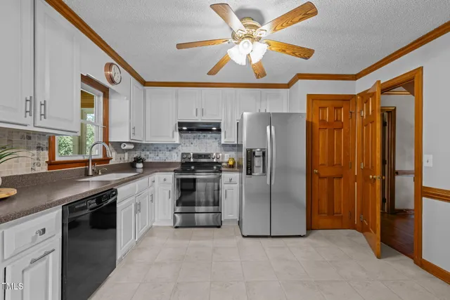 a kitchen with stainless steel appliances granite countertop a refrigerator a stove and a sink