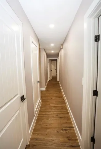 an empty room with wooden floor and a ceiling fan