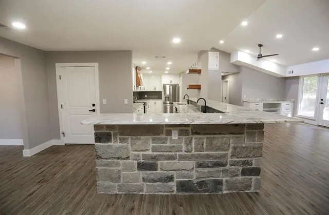 a view of kitchen with stainless steel appliances kitchen island sink and stove