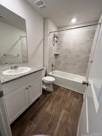 a bathroom with a double vanity sink toilet mirror and shower