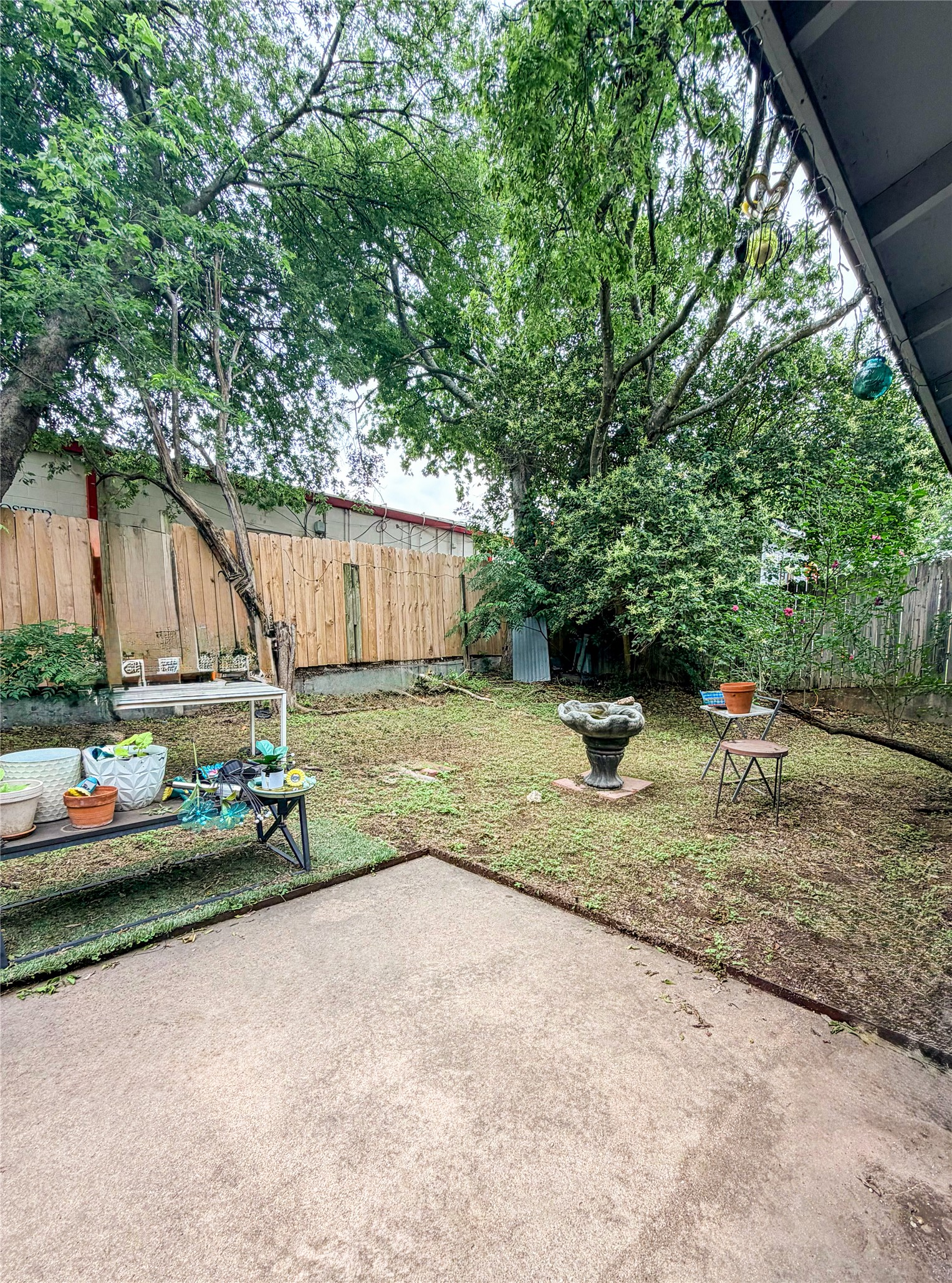 911 Kirschner Place, Unit A Austin, TX 78758 - Photo 6 of 12 A spacious backyard with mature trees and a wooden privacy fence, perfect for outdoor living.