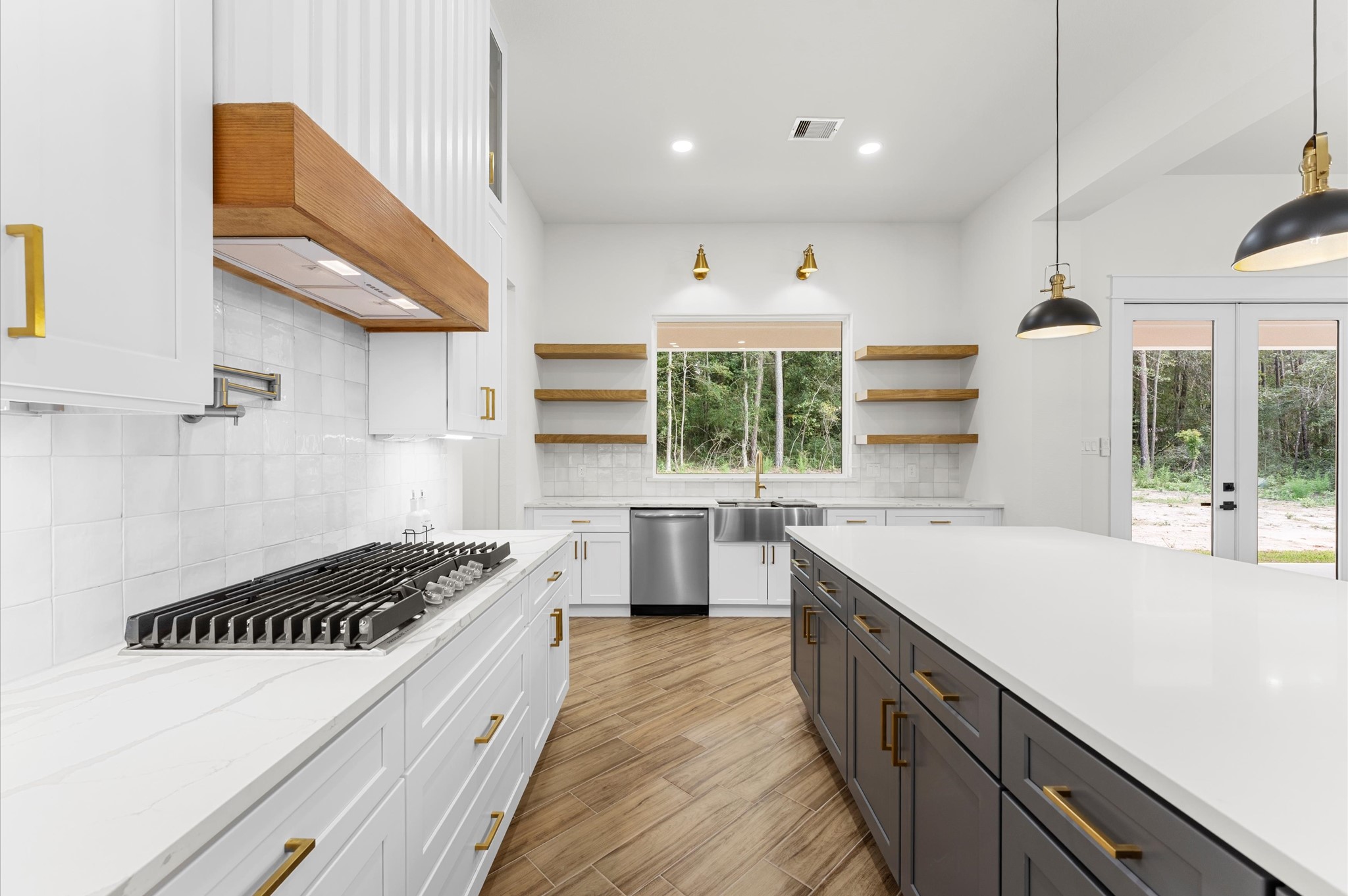 118 Ranger Road Huntsville, TX 77340 - Photo 16 of 49 Chef’s dream kitchen featuring custom cabinetry, oversized island, quartz counters, modern fixtures, and abundant windows that overlook the backyard.
