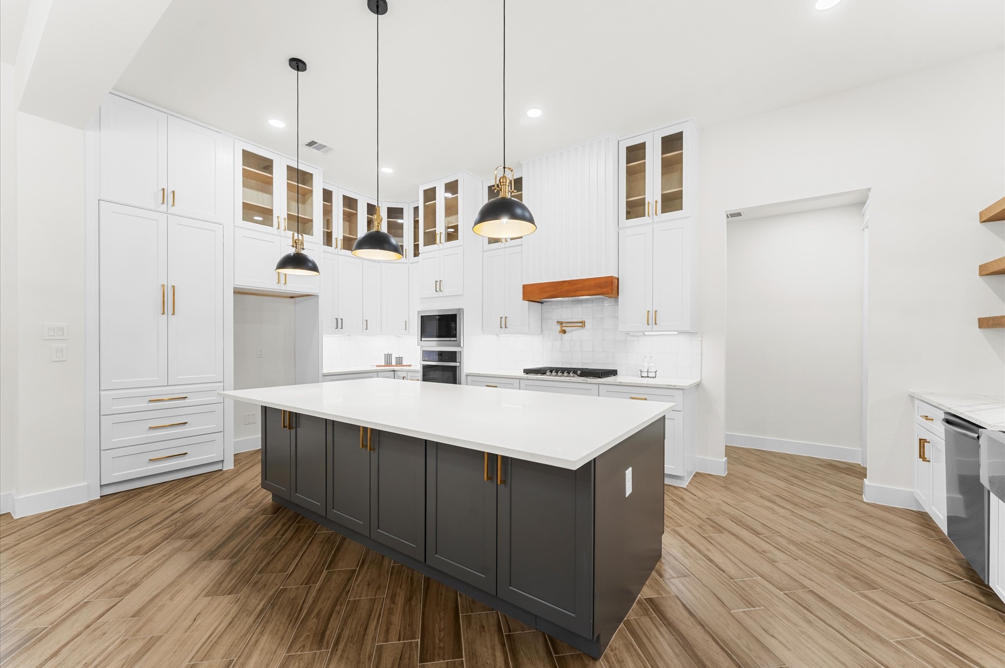 118 Ranger Road Huntsville, TX 77340 - Photo 18 of 49 Chef’s dream kitchen featuring custom cabinetry, oversized island, quartz counters, modern fixtures, and abundant windows that overlook the backyard.