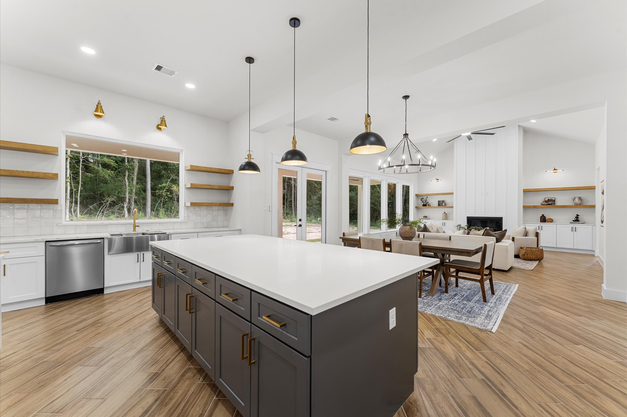 118 Ranger Road Huntsville, TX 77340 - Photo 19 of 49 Chef’s dream kitchen featuring custom cabinetry, oversized island, quartz counters, modern fixtures, and abundant windows that overlook the backyard.