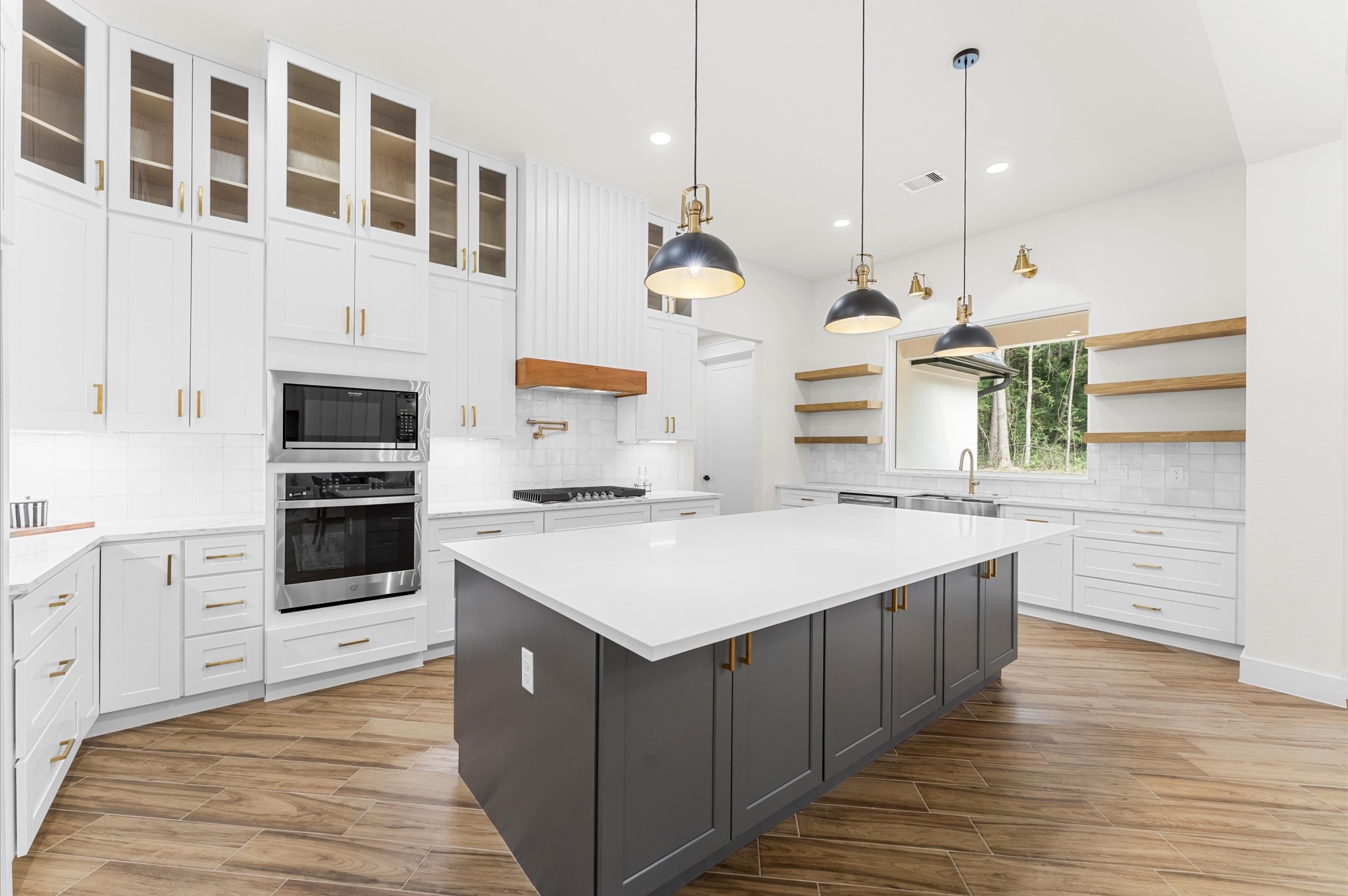 118 Ranger Road Huntsville, TX 77340 - Photo 21 of 49 Chef’s dream kitchen featuring custom cabinetry, oversized island, quartz counters, modern fixtures, and abundant windows that overlook the backyard.