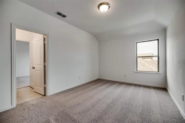 a view of an empty room with wooden floor fireplace and a window