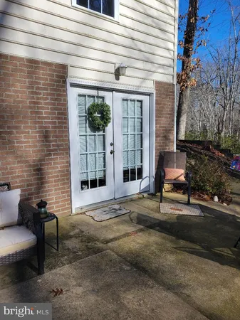 a view of a patio with a table and chairs and floor to ceiling window