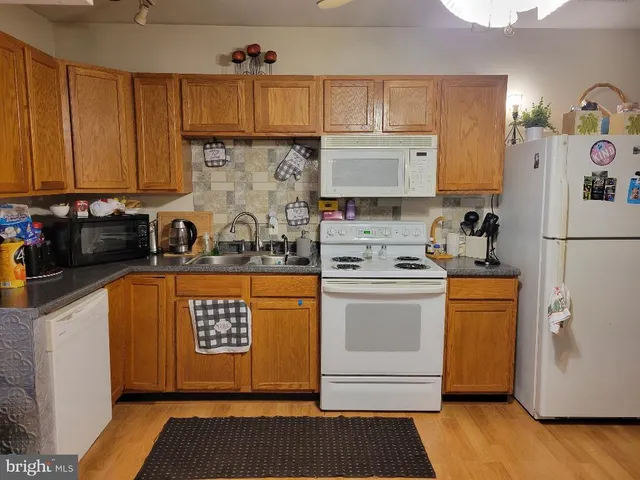 a kitchen with stainless steel appliances granite countertop a refrigerator sink and stove