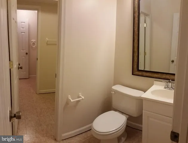 a bathroom with a toilet sink vanity and mirror