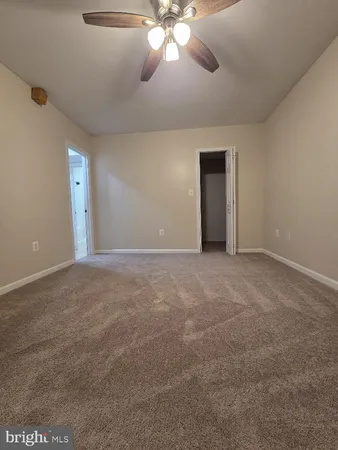 a view of an empty room with a chandelier fan