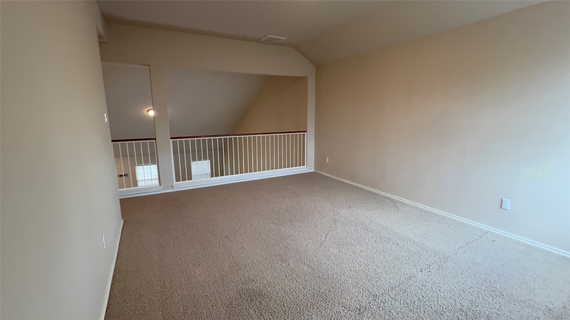 357 Nottingham Loop Kyle, TX 78640 - Photo 13 of 22 An airy upper-level loft features wall-to-wall carpeting and overlooks the living space below.