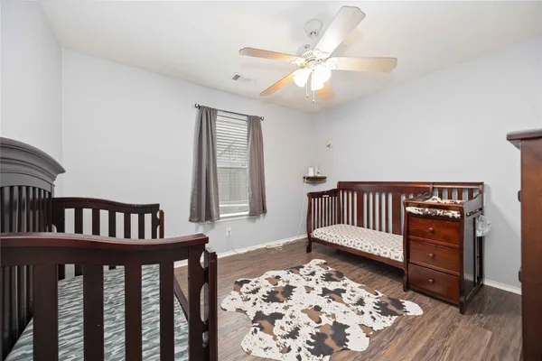 a view of a bedroom with wooden floor