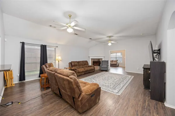 a living room with furniture and a wooden floor