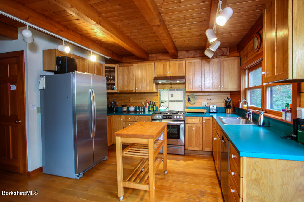 7 Mary Lyon Road Buckland, MA 01370 - Photo 10 of 60 a kitchen with stainless steel appliances granite countertop a refrigerator a sink dishwasher a stove and a dining table with wooden floor